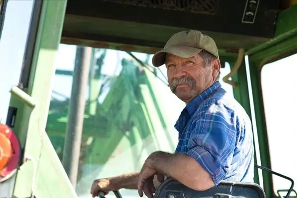 Western Canadian farmer standing in a wheat field, representing the challenge of high fertilizer prices despite local production
